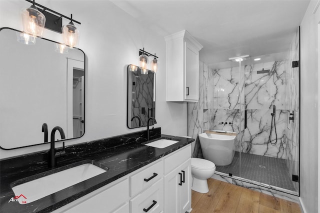 full bathroom with a sink, a marble finish shower, and wood-type flooring