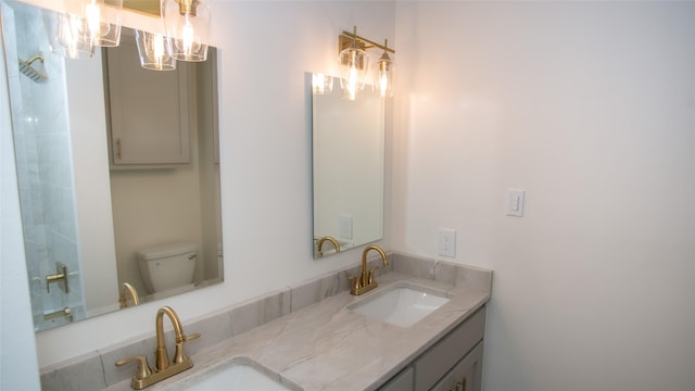 full bath featuring double vanity, toilet, a shower, and a sink