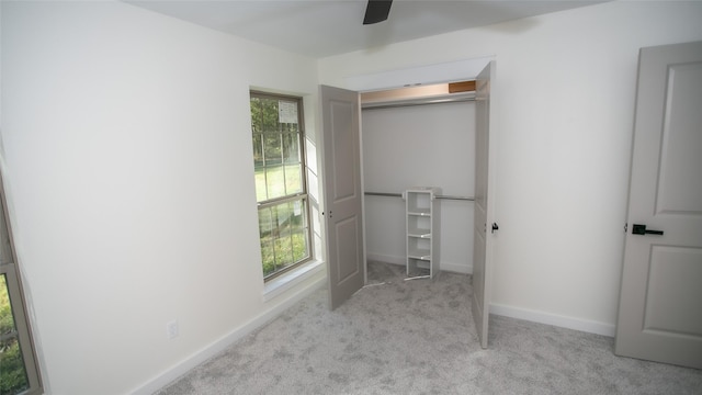 unfurnished bedroom featuring a closet, a ceiling fan, baseboards, and carpet floors