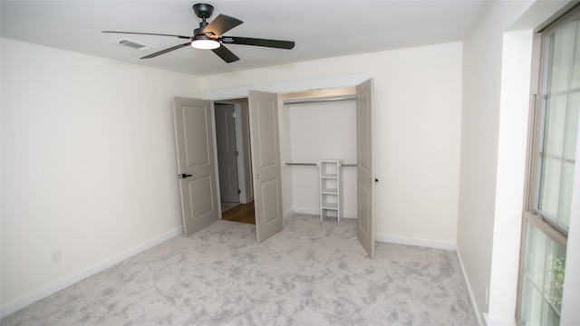 unfurnished bedroom with baseboards, visible vents, ceiling fan, a closet, and carpet flooring