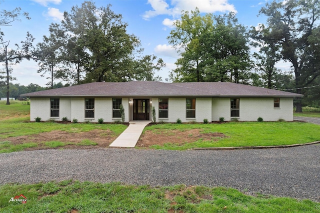 ranch-style home featuring brick siding and a front yard