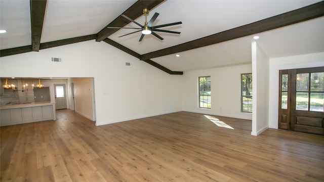 unfurnished living room featuring light wood-type flooring, visible vents, beamed ceiling, and a ceiling fan