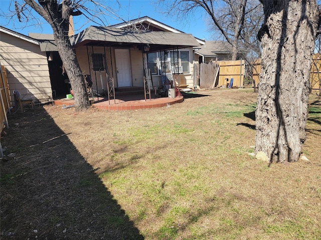 rear view of property with a lawn and a fenced backyard