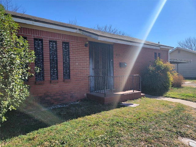 view of front of house with brick siding and a front lawn