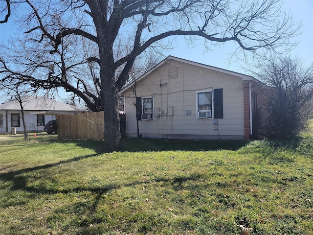 rear view of house featuring cooling unit, a yard, and fence