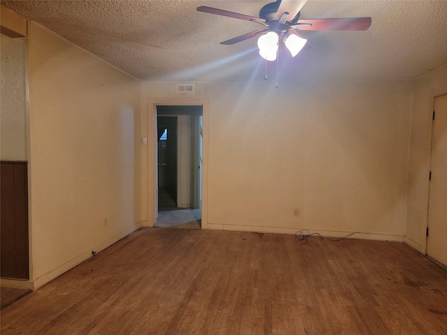 unfurnished room featuring visible vents, a textured ceiling, wood finished floors, and a ceiling fan