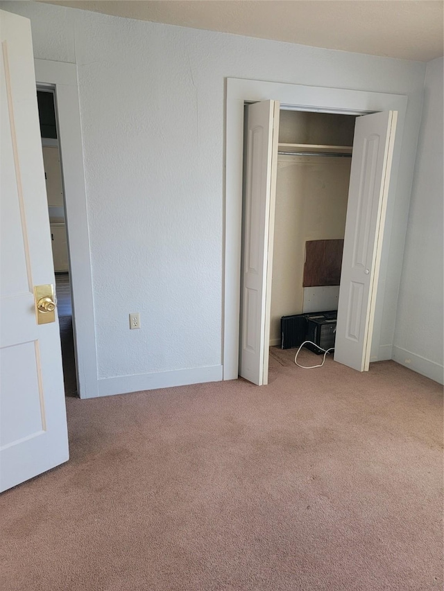 unfurnished bedroom with a closet, carpet flooring, and a textured wall