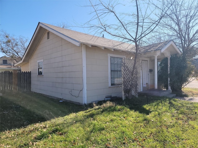 view of front of home featuring a shingled roof, a front yard, fence, and crawl space