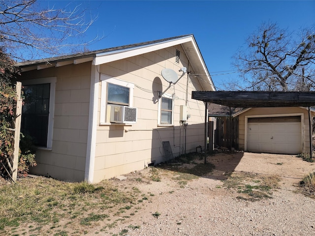 view of side of home featuring cooling unit, an outbuilding, and driveway