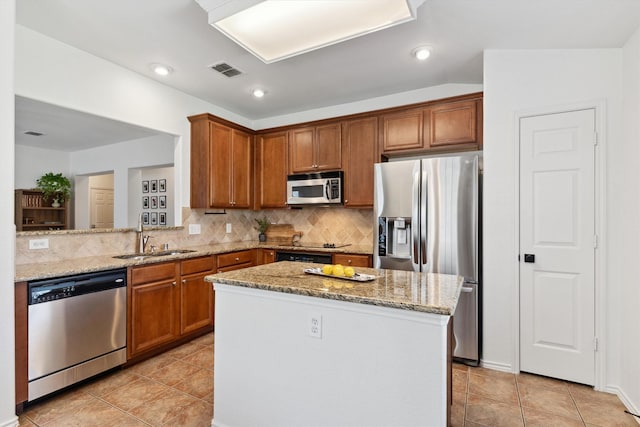 kitchen featuring light stone counters, visible vents, a sink, decorative backsplash, and appliances with stainless steel finishes