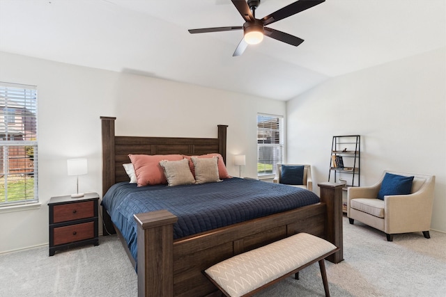 bedroom featuring multiple windows, light carpet, lofted ceiling, and ceiling fan