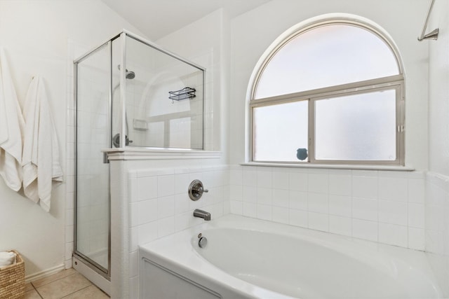 full bathroom with tile patterned floors, a bath, and a shower stall