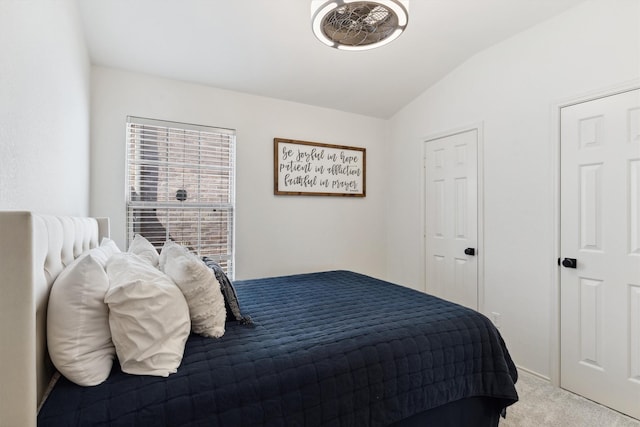 bedroom featuring lofted ceiling and light carpet