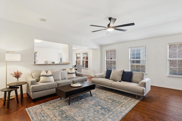 living room featuring visible vents, wood finished floors, baseboards, ceiling fan, and vaulted ceiling