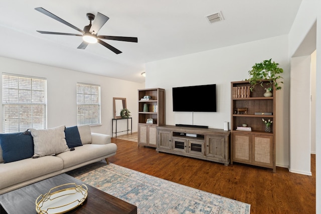 living room with visible vents, lofted ceiling, wood finished floors, and a ceiling fan