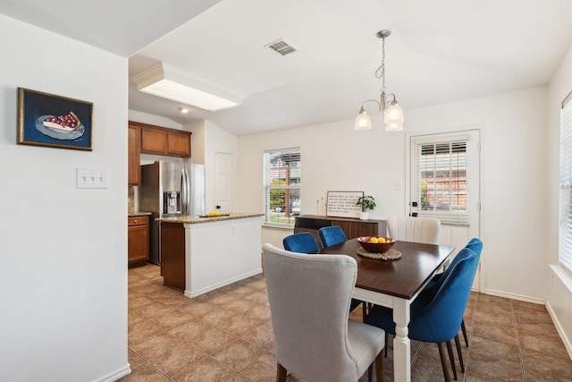 dining space featuring baseboards, visible vents, lofted ceiling, and an inviting chandelier