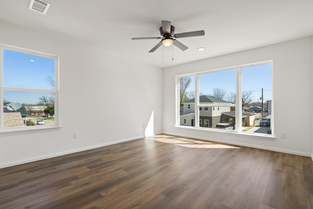 unfurnished room with visible vents, ceiling fan, baseboards, and wood finished floors