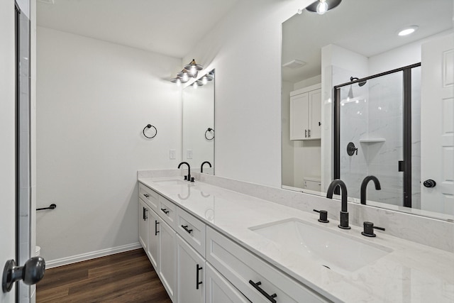 full bathroom with a sink, toilet, wood finished floors, and a shower stall