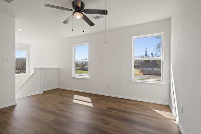 unfurnished room featuring a healthy amount of sunlight, baseboards, and wood finished floors