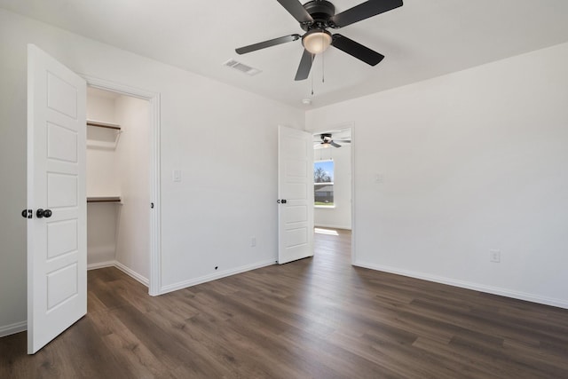 unfurnished room with visible vents, baseboards, and dark wood-style flooring