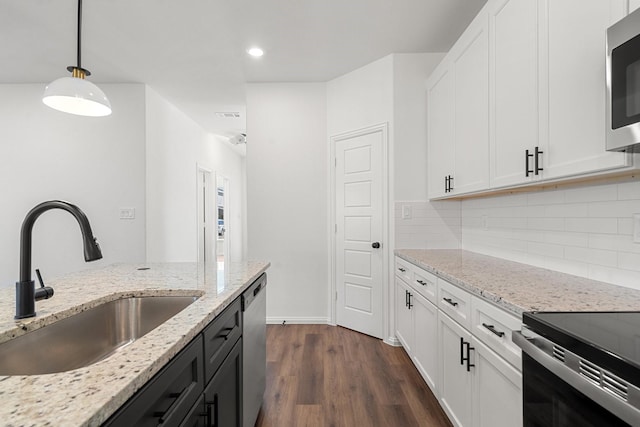 kitchen with a sink, stainless steel appliances, dark wood-style flooring, and white cabinetry