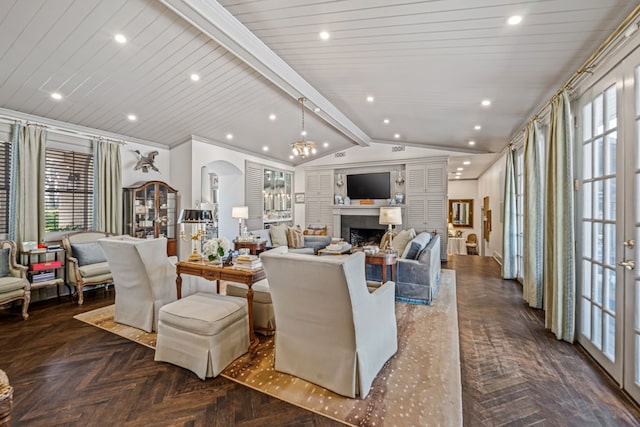 living area featuring lofted ceiling with beams, arched walkways, a wealth of natural light, and a fireplace