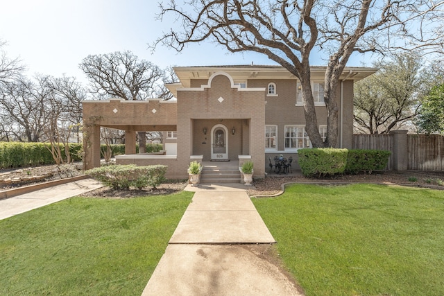 view of front of home with a front lawn, fence, and brick siding