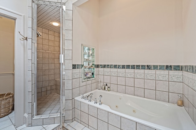 full bath with a stall shower, a whirlpool tub, and tile patterned flooring