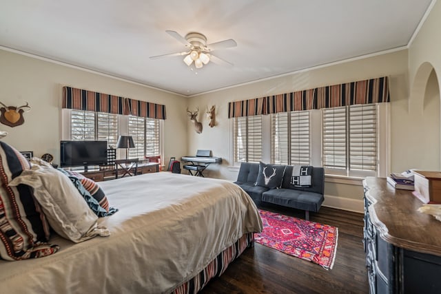 bedroom with crown molding, wood finished floors, baseboards, and ceiling fan