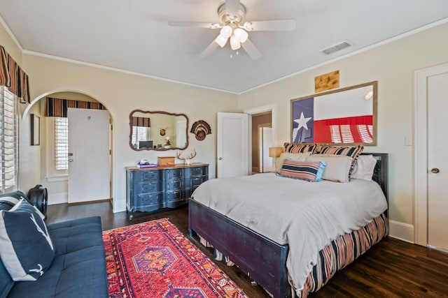 bedroom featuring wood finished floors, visible vents, baseboards, arched walkways, and crown molding