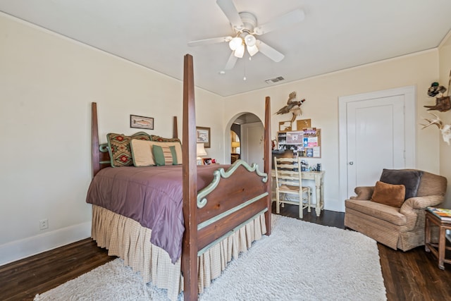 bedroom featuring visible vents, a ceiling fan, wood finished floors, arched walkways, and baseboards