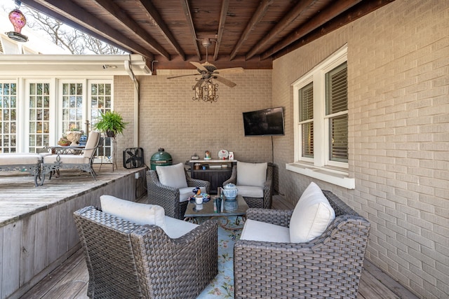 wooden deck with outdoor lounge area and ceiling fan