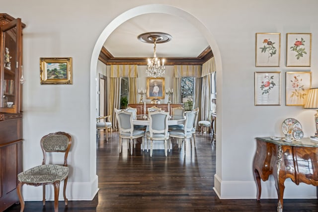 dining room featuring wood finished floors, arched walkways, a chandelier, and baseboards