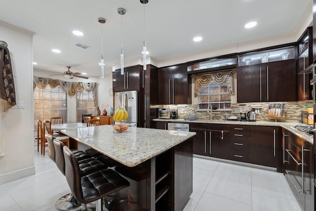 kitchen with a center island, visible vents, backsplash, and stainless steel appliances