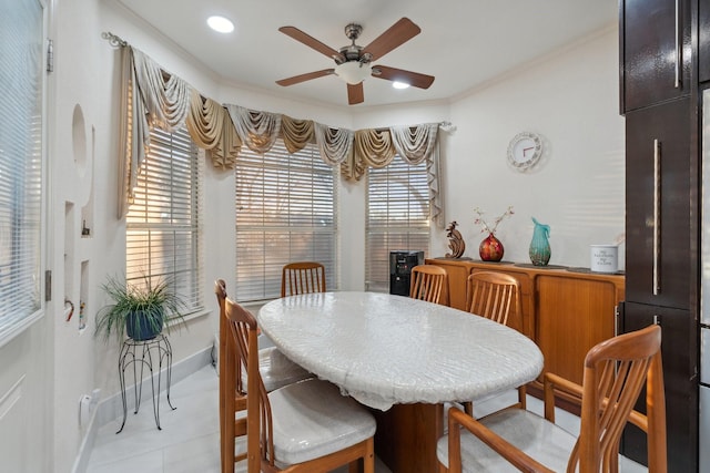 dining space with crown molding, a ceiling fan, and baseboards