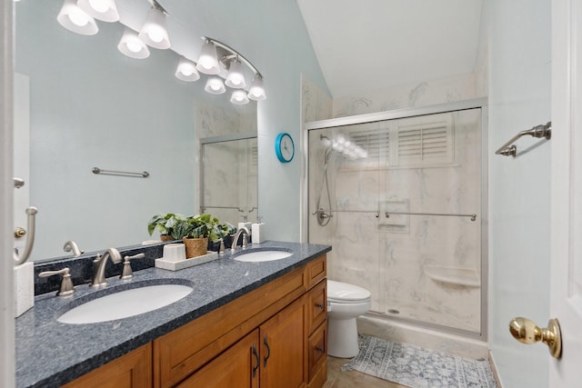 bathroom featuring a sink, toilet, double vanity, and a shower stall