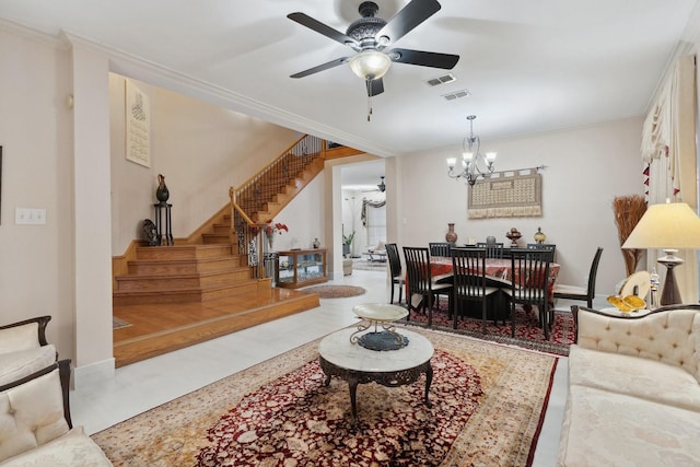 living room featuring crown molding, stairway, ceiling fan with notable chandelier, and visible vents