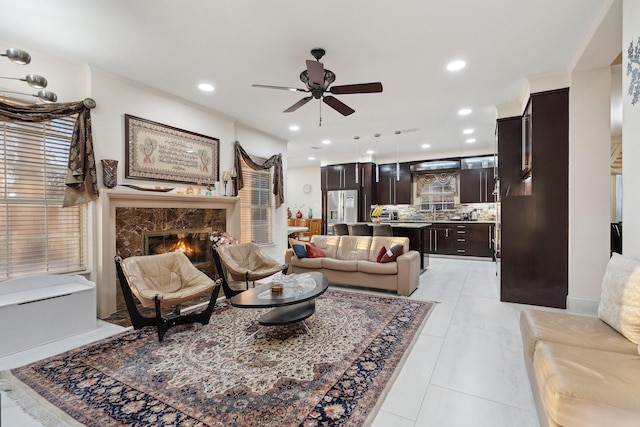 living area featuring ceiling fan, light tile patterned floors, recessed lighting, and a premium fireplace