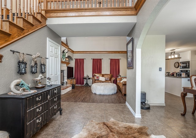 bedroom featuring tile patterned floors, baseboards, arched walkways, and a textured wall