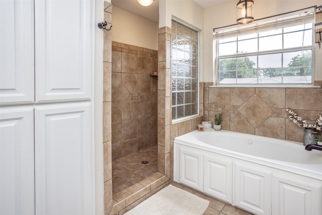 full bath with tile patterned floors, a bath, and tiled shower