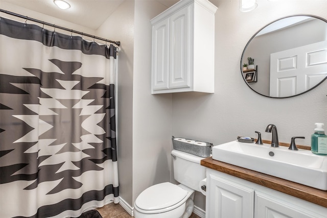 full bath with toilet, vanity, and baseboards