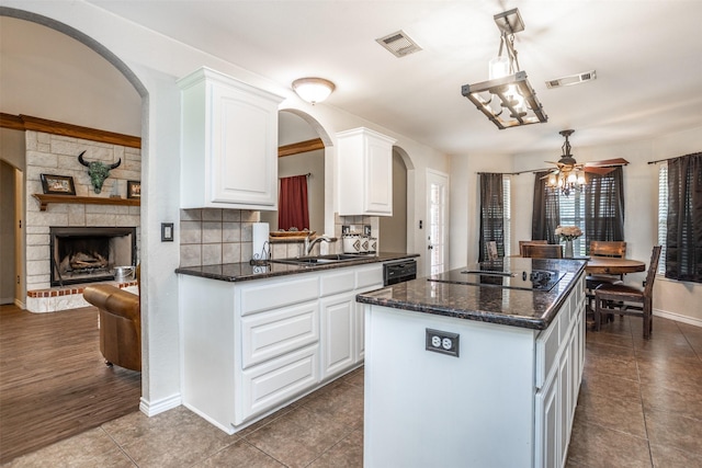 kitchen with a sink, black appliances, visible vents, and a center island