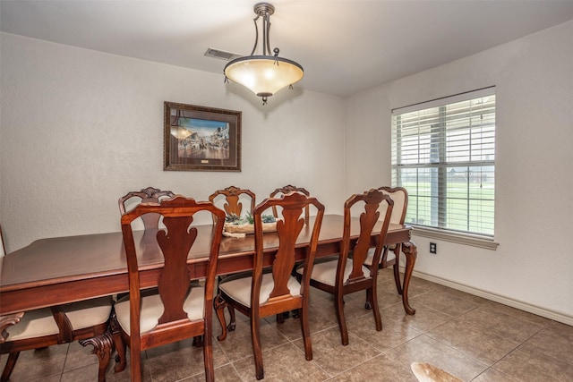 tiled dining space with visible vents and baseboards