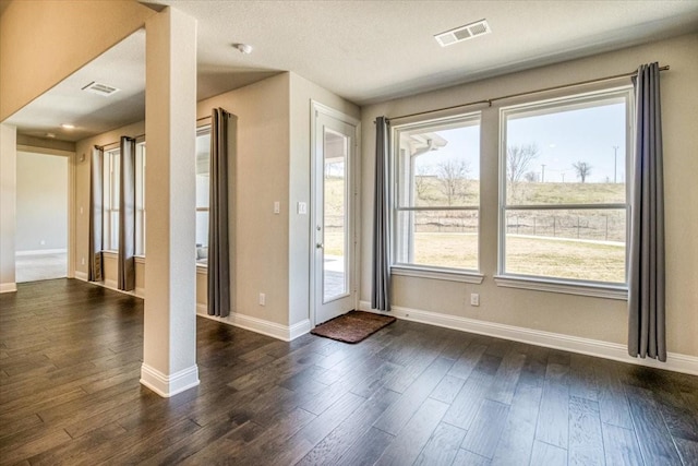 entryway with visible vents, baseboards, and dark wood-type flooring