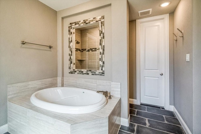 full bath featuring tile patterned flooring, visible vents, baseboards, tiled shower, and a bath