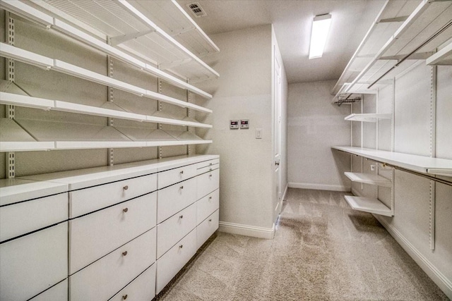 walk in closet with visible vents and light carpet