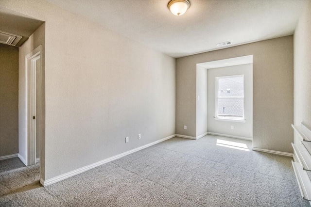 unfurnished room featuring visible vents, baseboards, and light colored carpet