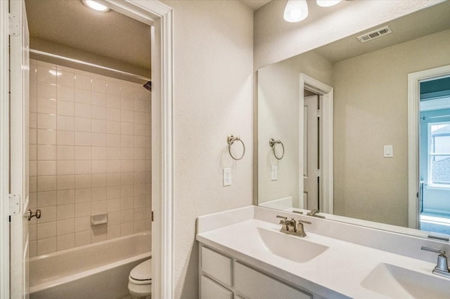 bathroom featuring double vanity, shower / bathing tub combination, visible vents, and a sink