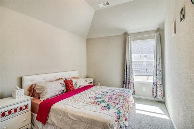 bedroom with visible vents, baseboards, carpet, lofted ceiling, and a textured wall