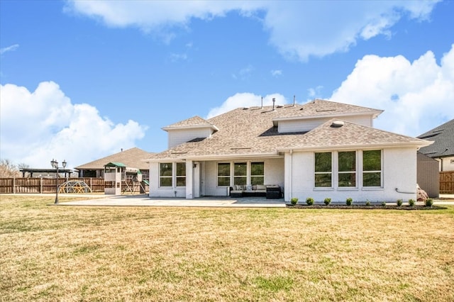 rear view of house with fence, a lawn, roof with shingles, and a patio area